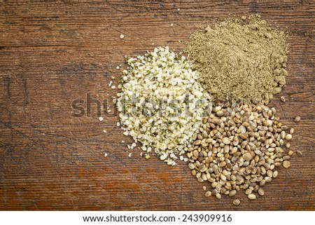 hemp seed, hearts and protein powder - small piles on a grunge wood - top view