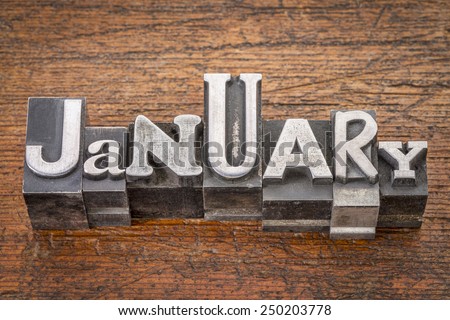 January word in mixed vintage metal type printing blocks over grunge wood