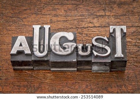 August  word in mixed vintage metal type printing blocks over grunge wood
