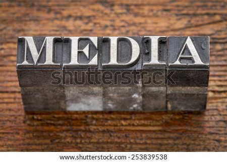 media word in mixed vintage metal type printing blocks over grunge wood