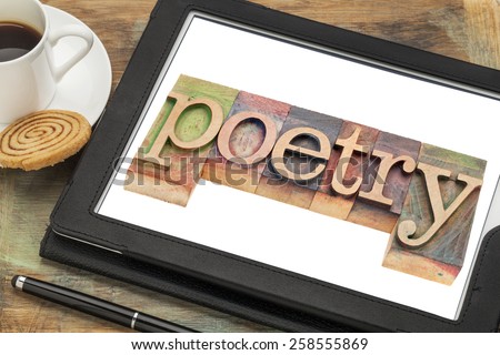 poetry word typography - text in letterpress wood type on a digital tablet with a cup of coffee