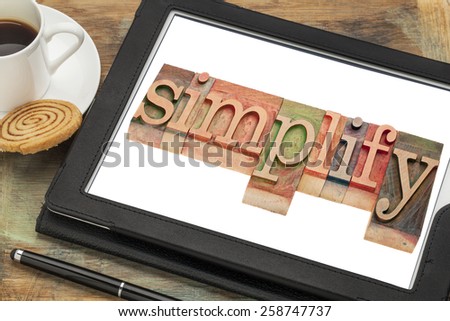 simplify word typography - text in letterpress wood type on a digital tablet with a cup of coffee