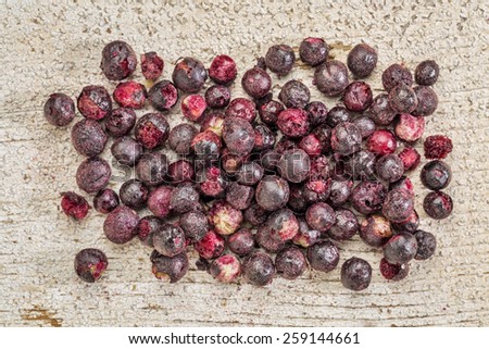 Freeze dried elderberries against rustic barn wood. Elderberries are rich in antioxidants and minerals which make them perfect in battling the common cold.