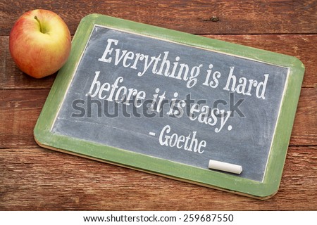 Everything is hard before it is easy - Goethe quote  on a slate blackboard against red barn wood