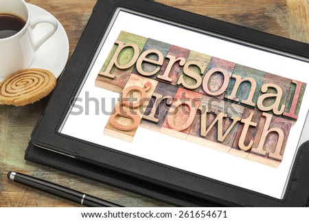 personal growth typography - text in letterpress wood type on a digital tablet with a cup of coffee