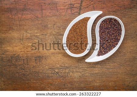 kaniwa and black quinoa  gluten free grains on on teardrop shaped bowls against rustic wood with a copy space