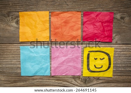 colorful blank sticky notes with smiley against grained wood