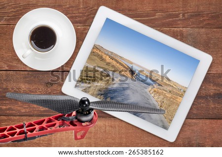 aerial landscape photography concept - reviewing aerial pictures of  Horsetooth Reservoir in Colorado on a digital tablet with a drone rotor in foreground. Screen picture copyright by the photographer