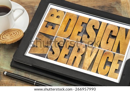 web design service word abstract - isolated text in letterpress wood type on a digital tablet with a cup of coffee