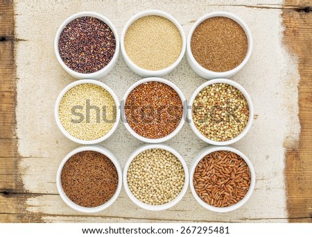 nine healthy, gluten free grains (quinoa, brown rice, millet, amaranth, teff, buckwheat, sorghum), kaniwa), top view of small round bowls against rustic barn wood