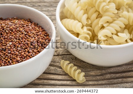 healthy, gluten free quinoa grain and pasta - small ceramic bowls against grained wood