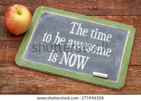The time be awesome is now - motivational words on a slate blackboard against red barn wood