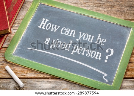 How can you be a good person? An inspirational question on a  blackboard with a white chalk and books against rustic wooden table