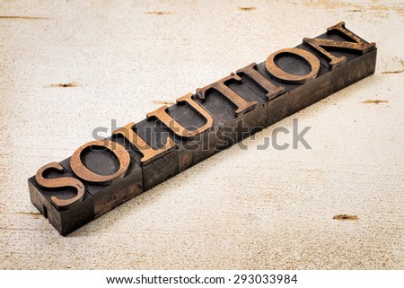 solution word in vintage letterpress wood type against white painted rustic barn wood