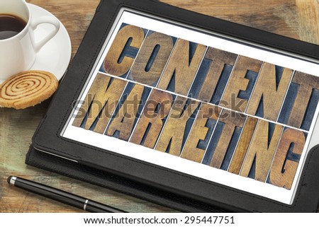 content marketing  - text in grunge letterpress wood type printing blocks on a digital tablet with a cup of coffee
