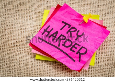 try harder - motivation words on a  purple sticky note against burlap canvas