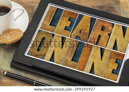learn online word abstract - text in letterpress wood type on a digital tablet with a cup of coffee