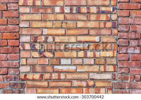 old brick wall background texture with a window covered by different bricks