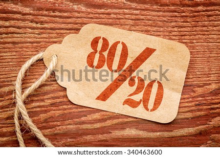 Pareto principle or eighty-twenty rule represented on a paper price tag against rustic wood