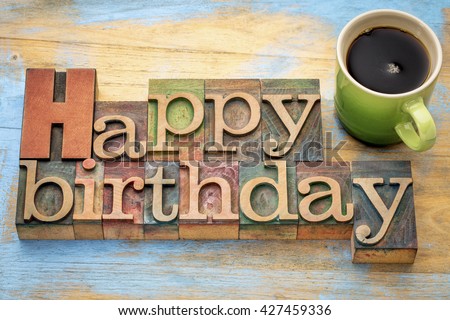 Happy Birthday greeting card - word abstract in vintage letterpress wood type stained by color inks with a green stoneware cup of coffee