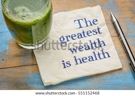 The greatest wealth is health advice or reminder - handwriting on a napkin with a glass of fresh, green, vegetable juice