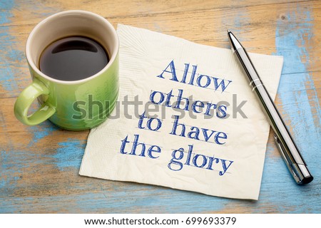 Allow others to have a glory - handwriting on a napkin with a cup of espresso coffee