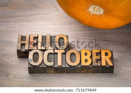 hello October greeting card - letterpress wood type blocks against grained wood with a pumpkin