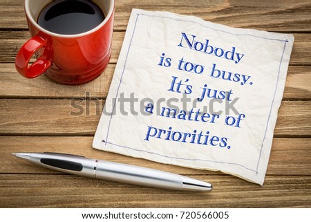 Nobody is too busy, it is a matter of priorities - handwriting on a napkin with a cup of espresso coffee