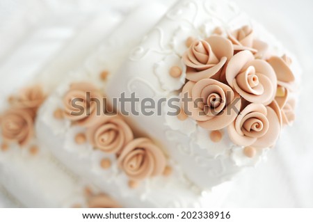 Wedding cake with pink flowers on light background
