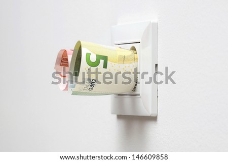 energy savings concept with power socket and money