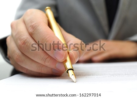businessman is fulfilling and signing contract with fountain pen