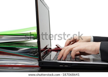 Accountant with full of documentation working on computer and using calculator