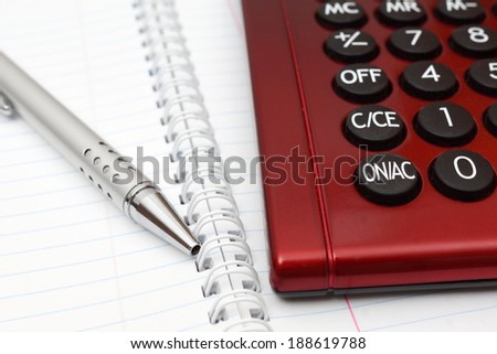 Pen, calculator and notebook close up