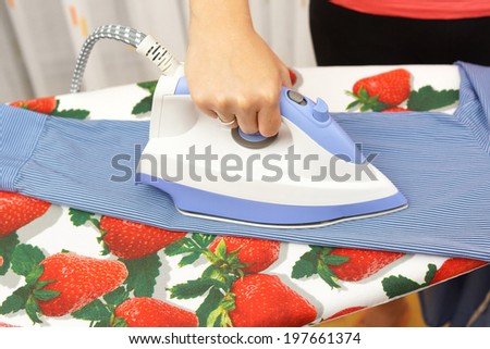 Woman\'s Hand Ironing sleeve On Ironing Board