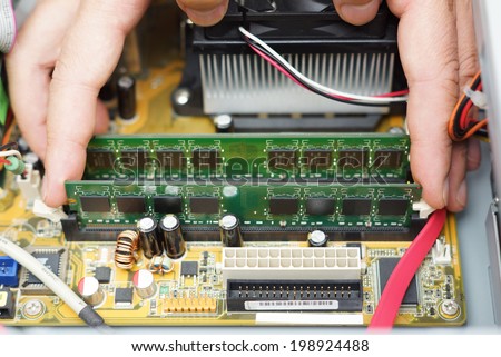 Computer repair.  Technician takes random access memory module out