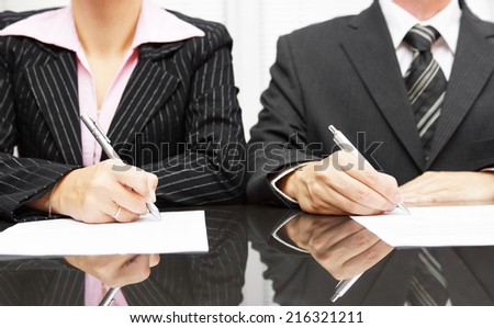 businesswoman and businessman signing contract after negotiations