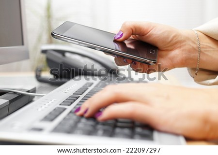 Woman is transferring application from computer to smart mobile phone