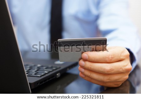 Businessman is using credit card for on line payment on laptop