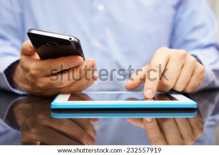 male is using smart mobile phone and tablet computer at the same time
