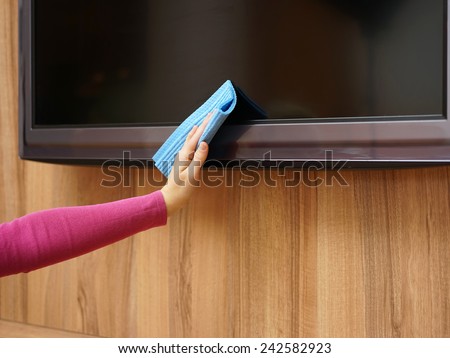 Cleaner from cleaning service is cleaning dirt and dust from tv and furniture