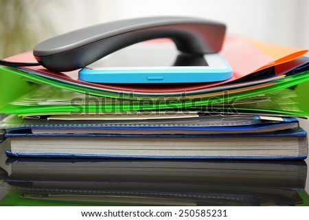 Handset and tablet computer on top of the files and folders. accounting and bookkeeping concept