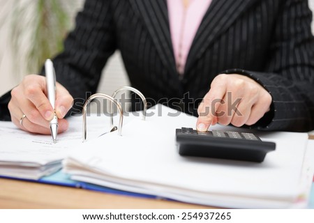 Busy female accountant working with documents