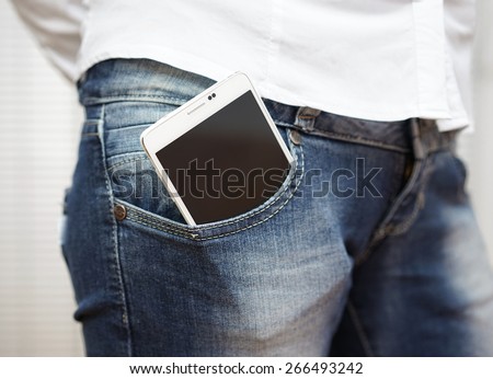 big white smart mobile phone in jeans pocket