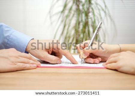 man is pointing a place where she should sign the agreement