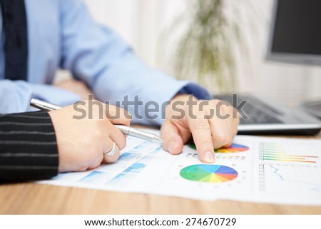 businessman and businesswoman discussing about company report in office