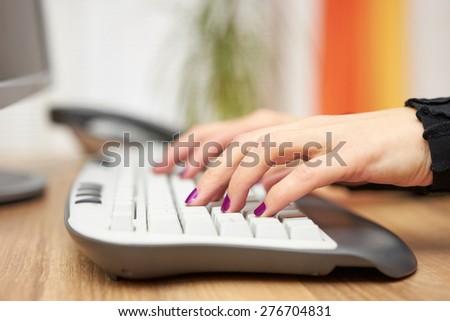 Woman is typing on computer keyboard at home