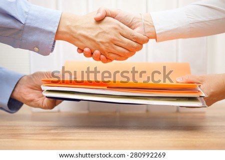 entrepreneur shaking hands with his accountant after passing documentation and invoices