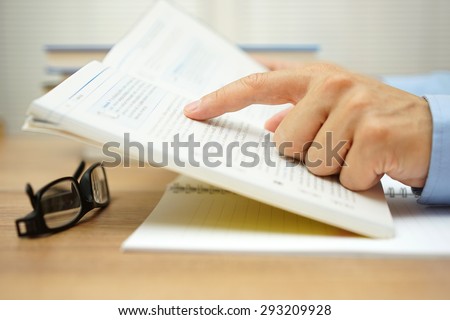 closeup of man hand reading a book
