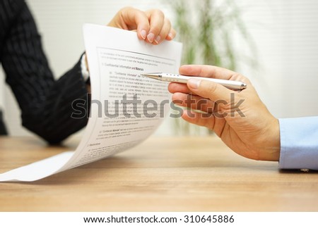 businesswoman holding legal document and  wants an explanation about article in contract