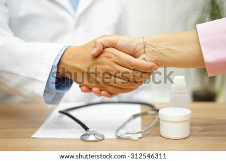 Satisfied patient is handshaking with good doctor over good health report